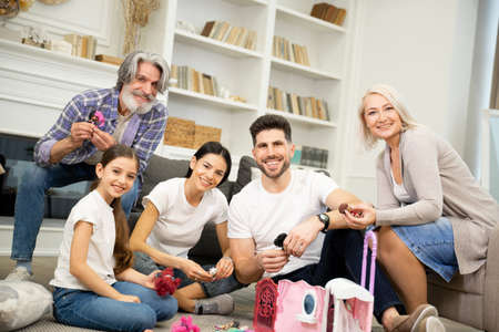 Portrait of big happy multigenerational family playing with little child girl