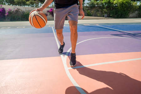 Legs of a professional basketball player dribbling the ball on the basketball fieldの写真素材