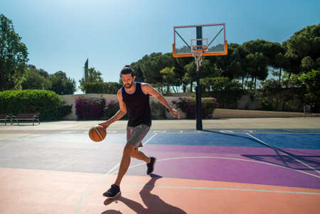 basketball player trains himself on a basketball court with a ballの写真素材