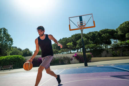 basketball player trains himself on a basketball court with a ballの写真素材