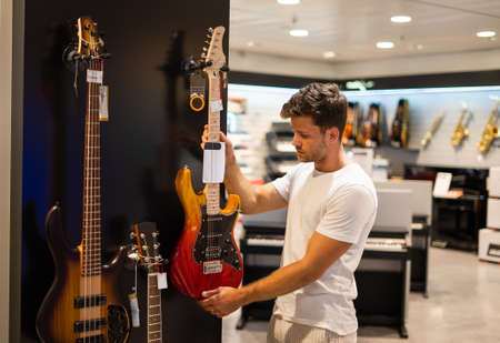 Guitarist buying musical instrument in storeの写真素材