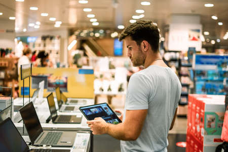 Client choosing laptop in storeの写真素材