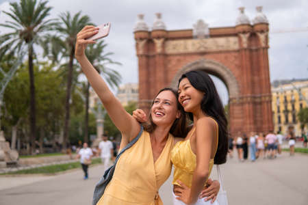 Travelling female friends taking selfie in cityの写真素材
