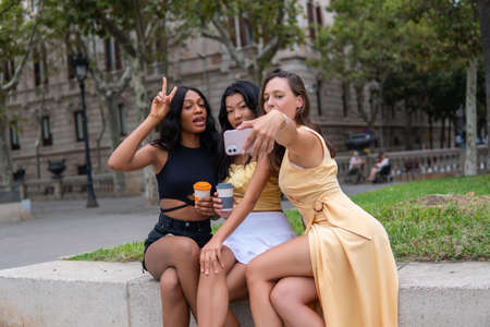 Multiethnic girlfriends taking selfie in cityの写真素材