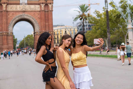 Group of diverse girlfriends taking selfie near historic buildingの写真素材