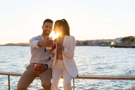 Loving ethnic couple taking self shot on seafrontの写真素材