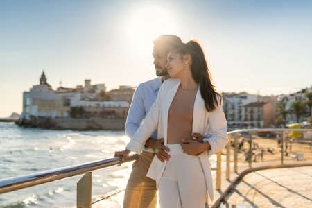 Carefree ethnic couple standing on embankment in summerの写真素材