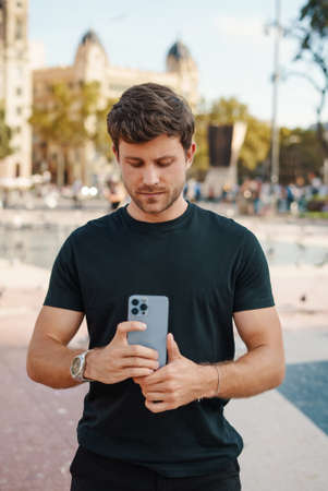 Stylish male talking photo on mobile phone in cityの写真素材