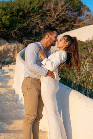 Loving Hispanic couple embracing on stairs in eveningの写真素材