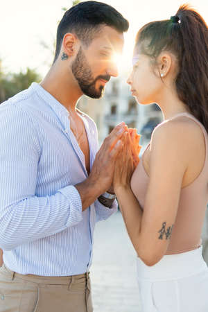Tender ethnic couple touching handsの写真素材