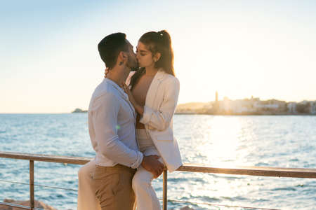 Ethnic couple in love kissing on sea embankmentの写真素材