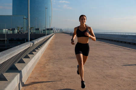 Determined sportswoman jogging on streetの写真素材