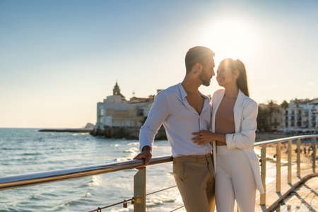 Cheerful ethnic couple standing on promenade in summerの写真素材