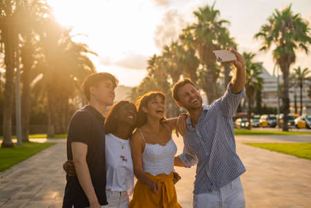 Young friends taking selfie on smartphoneの写真素材