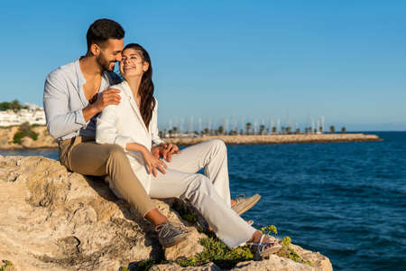 Hispanic couple in love on rocks at seasideの写真素材