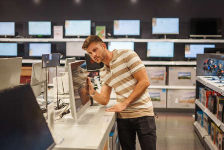 Male customer selecting monitor in shop