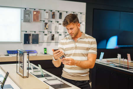 Man selecting smartphone from stallの写真素材