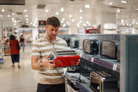 Man selecting toaster in mallの写真素材