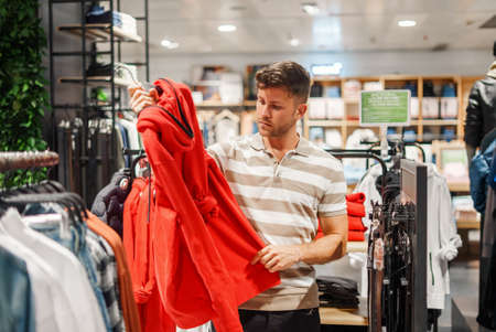 Man choosing hoodie in shopの写真素材