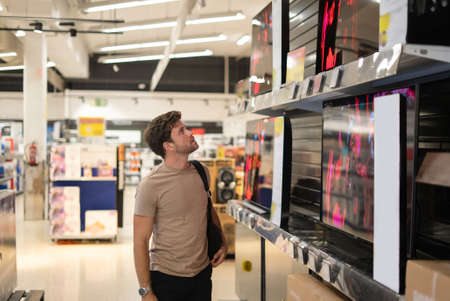 Man choosing TV in mallの写真素材