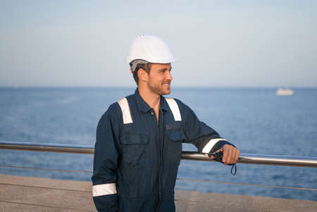 Worker in helmet standing near seaの写真素材