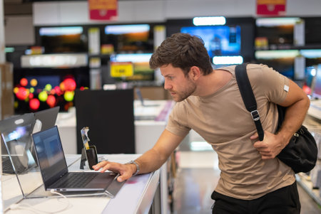 Man exploring new gadget in e storeの写真素材