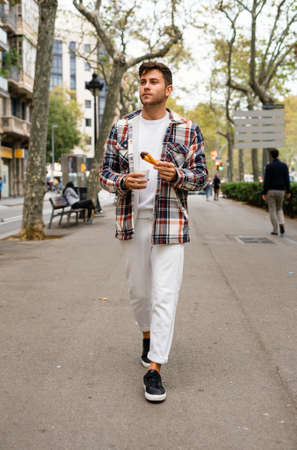 Man with churros dessert walking in streetの写真素材