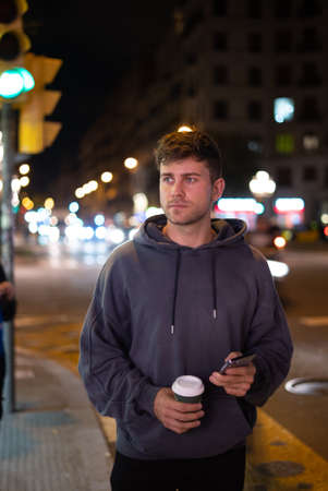 Man with coffee to go using cellphone