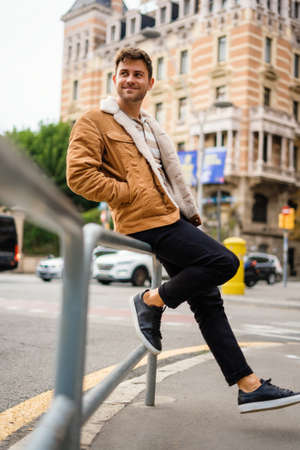 Happy guy leaning on fenceの写真素材