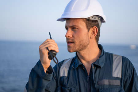 Technician with radio set near seaの写真素材