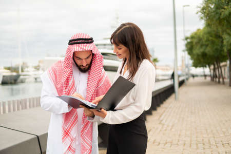 Arab man signing contract with female entrepreneurの写真素材