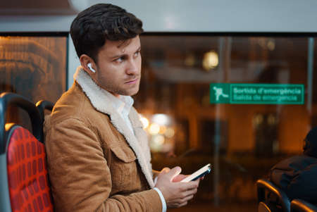 Man using smartphone and riding busの写真素材