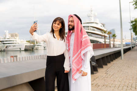 Businesswoman taking selfie with Arab manの写真素材