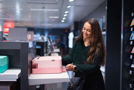 Happy woman choosing printer in mall