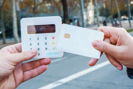 Crop woman making NFC payment in cityの写真素材
