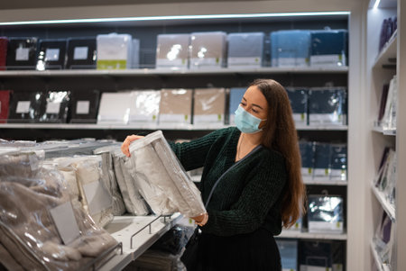 Woman selecting blanket in shopの写真素材