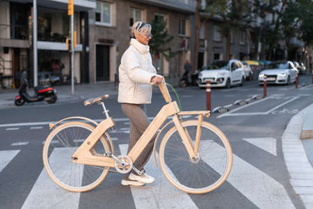Female with bike walking on roadの写真素材