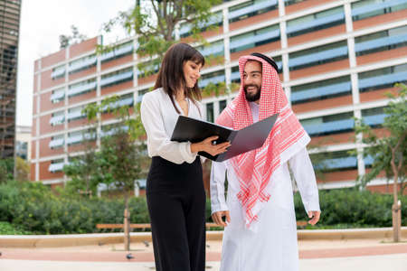 Female manager showing papers to Arab clientの写真素材