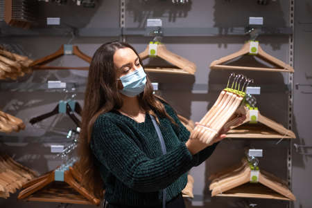 Female client choosing hangers during pandemicの写真素材