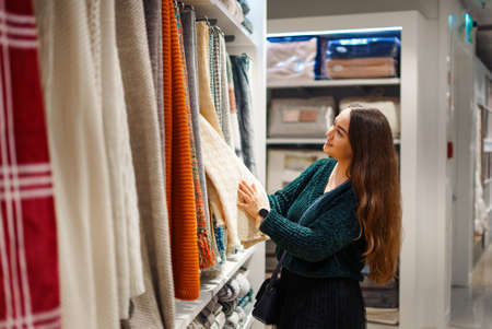 Happy smiling woman making shopping for her new home, walking in store of household goodsの写真素材