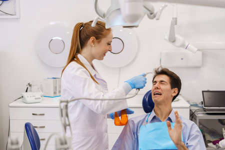 Cheerful dentist treating scared patientの写真素材