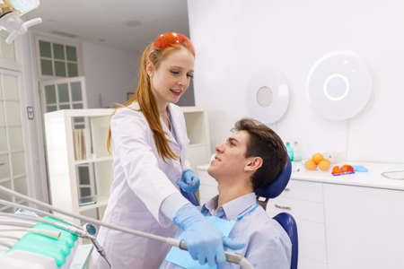Female dentist with drill preparing to heal manの写真素材