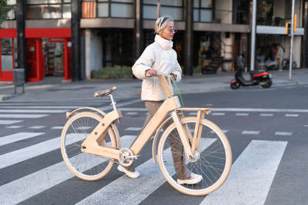 Female bicyclist crossing road in daytimeの写真素材