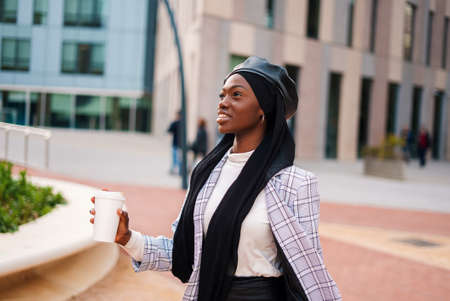 Cheerful black lady with takeaway beverage in parkの写真素材