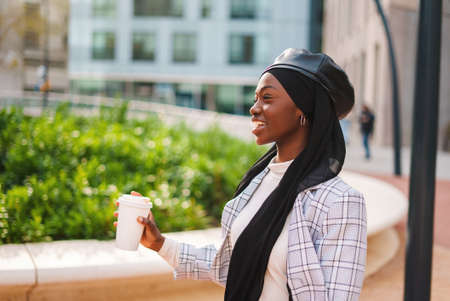 Happy Muslim black woman drinking coffee and laughingの写真素材