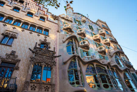 From below aged building with creative ornamental balconies and windows against blue sky on sunny day inの写真素材