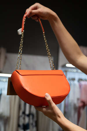 Crop woman examining bag in shopの写真素材