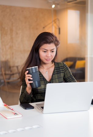 Smart lady with coffee working on netbookの写真素材
