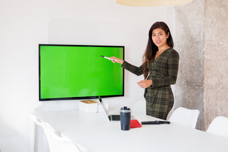 Positive lady pointing at chromakey display in officeの写真素材