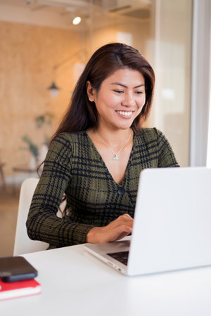 Cheerful office woman working on netbookの写真素材